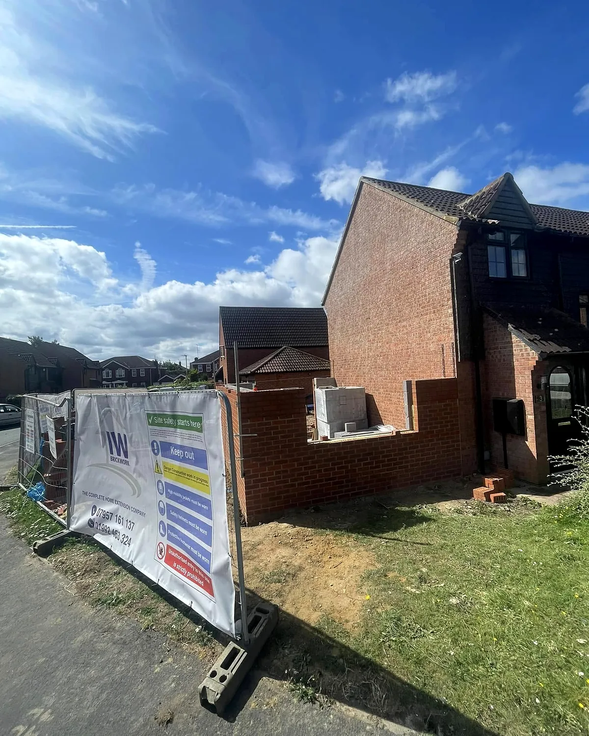 Brickwork coming up behind the site hoarding