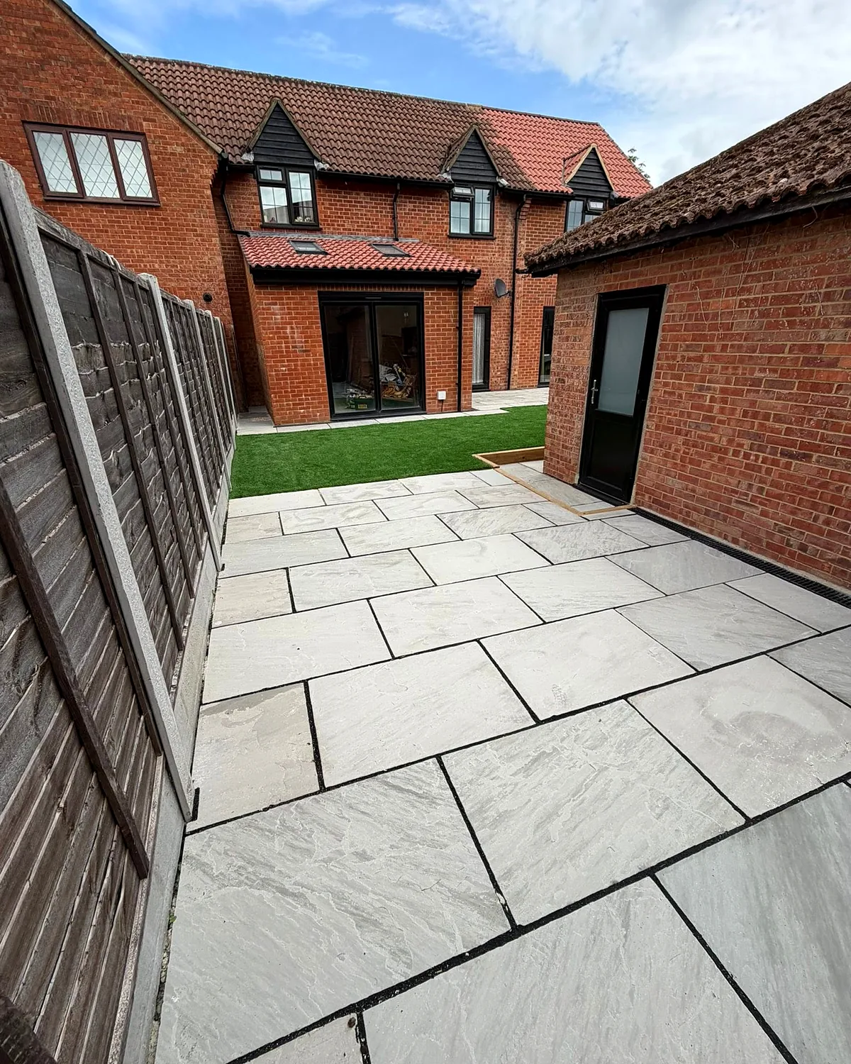 Patio, lawn and fencing at the side