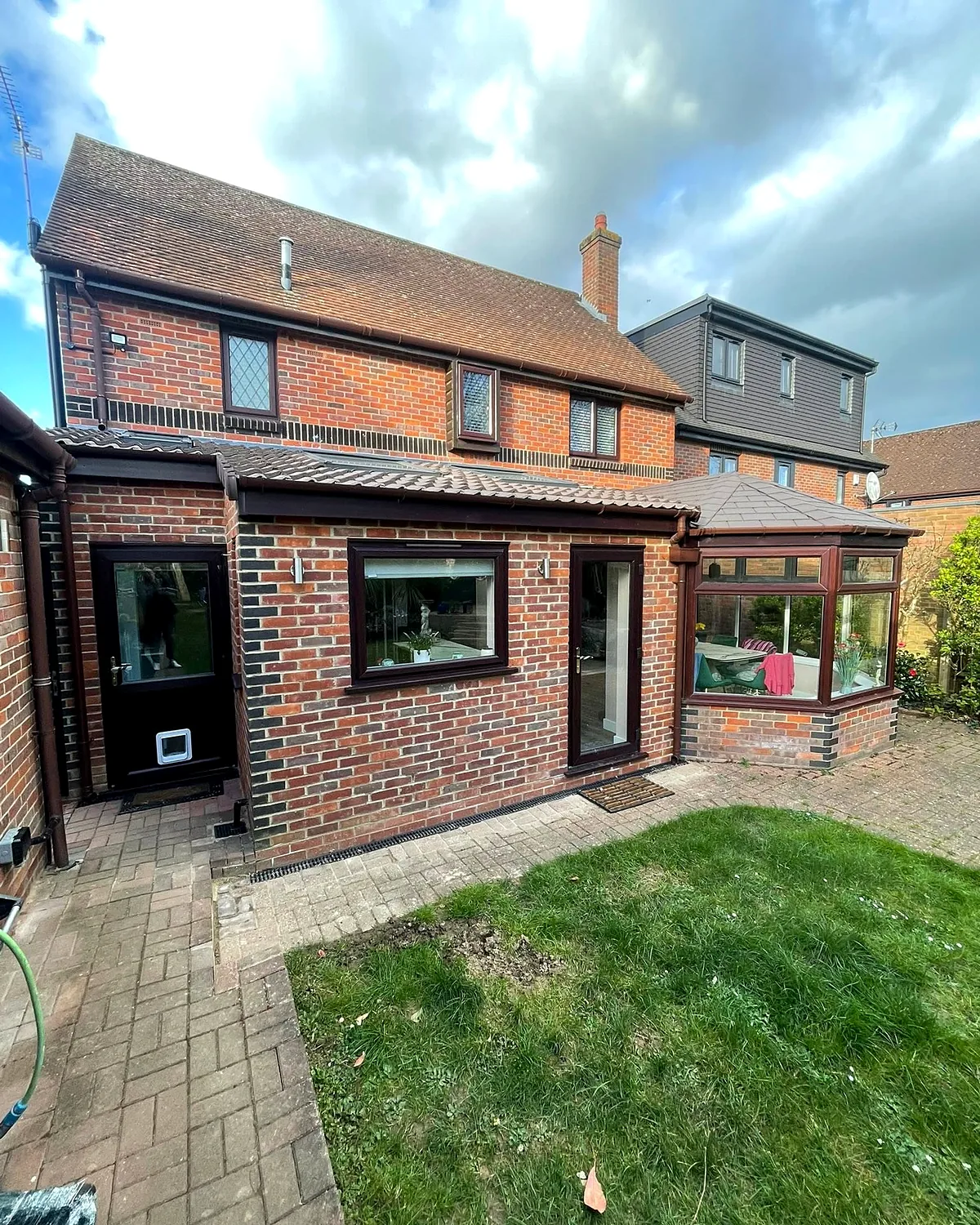 From the garden: The extension from the lawn, its brick matched to the house.